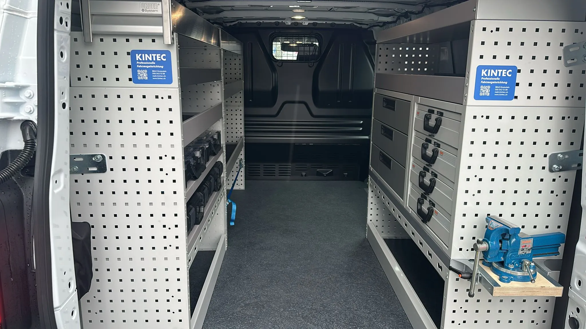 Beidseitig eingerichteter Laderaum eines VW T7 mit Regalen, Schubladen und Schraubstock